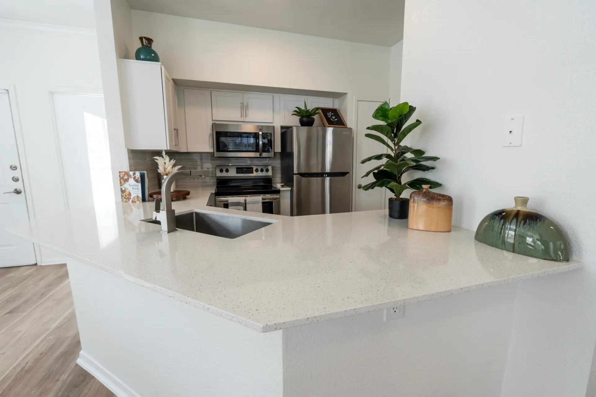 White quartz kitchen countertops with an undermount sink in a bright open kitchen